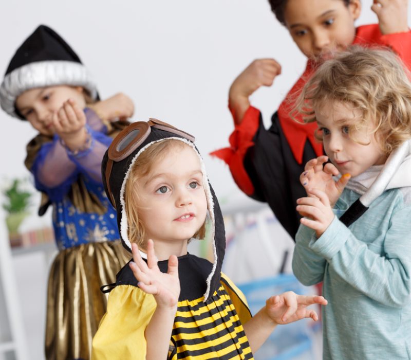 Kids in colorful costumes having fun on kindergarten party